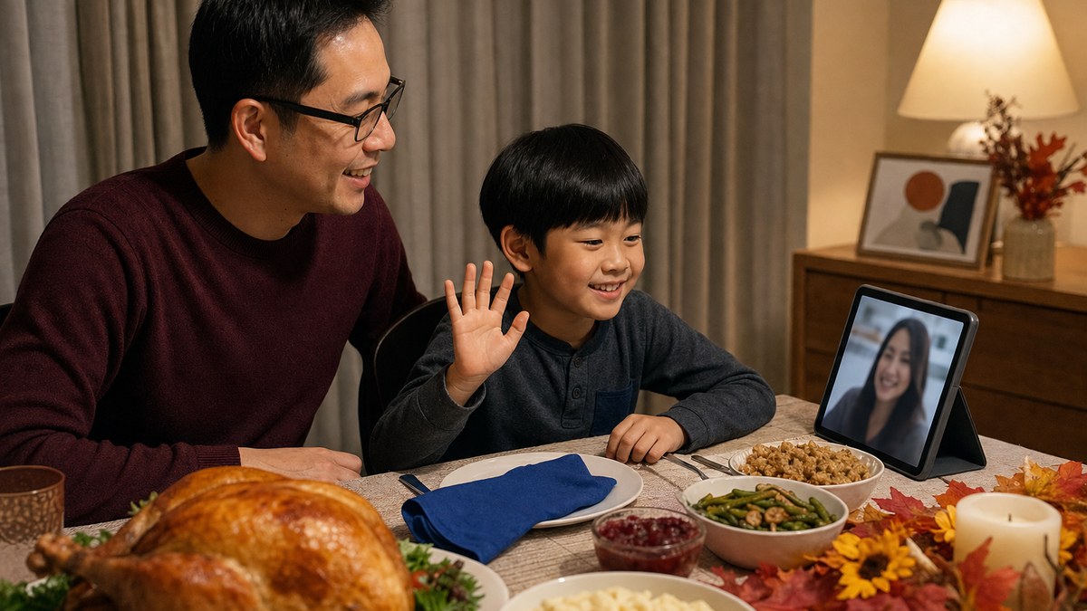 A father and his young son at a holiday dinner table in a Las Vegas home, the boy waving at a tablet video call with his mother